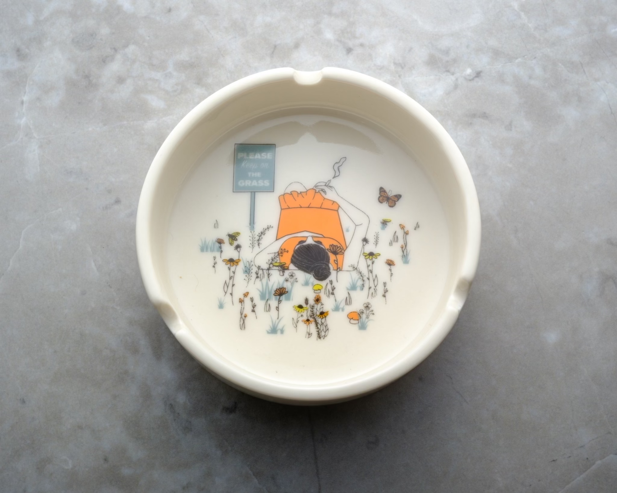 White porcelain ashtray with intricate detail and deep basin; designed to hold ash securely while adding a touch of humor, whimsy, and style to your cannabis ritual.