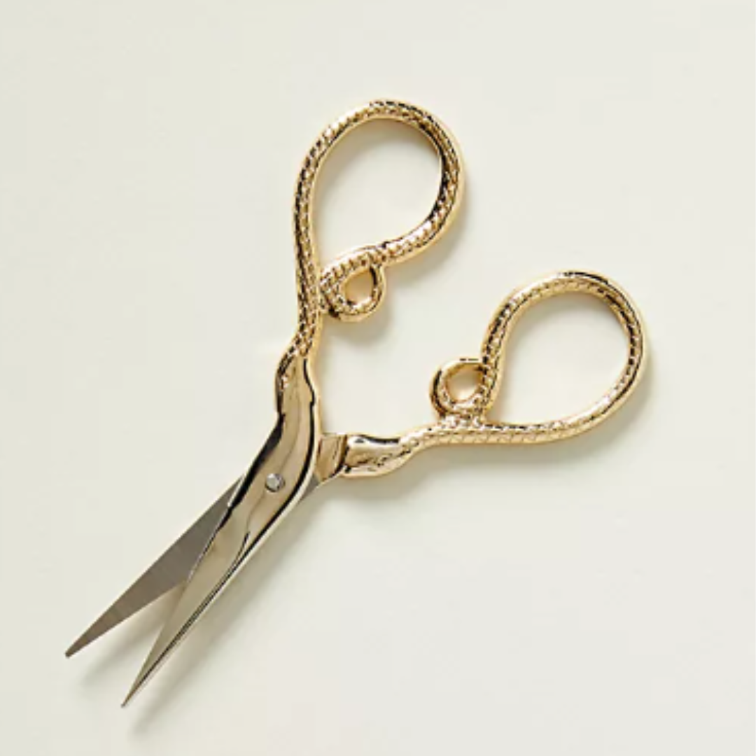 A pair of luxury precision trimming scissors featuring a unique python-skin texture on the gold-toned handles. The surgical-grade stainless steel blades are slender and sharp, designed for the fine-tuning of cannabis flower and hand-rolled joints.