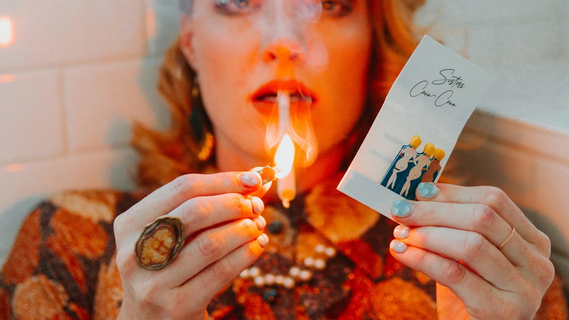 Sisters Cann Cann Matches lighting a joint being smoked by a model. This beautiful lifestyle shot represents the luxury quality of Rogue Paq Cannabis Smoking Accessories intended to Raise Your Ritual.