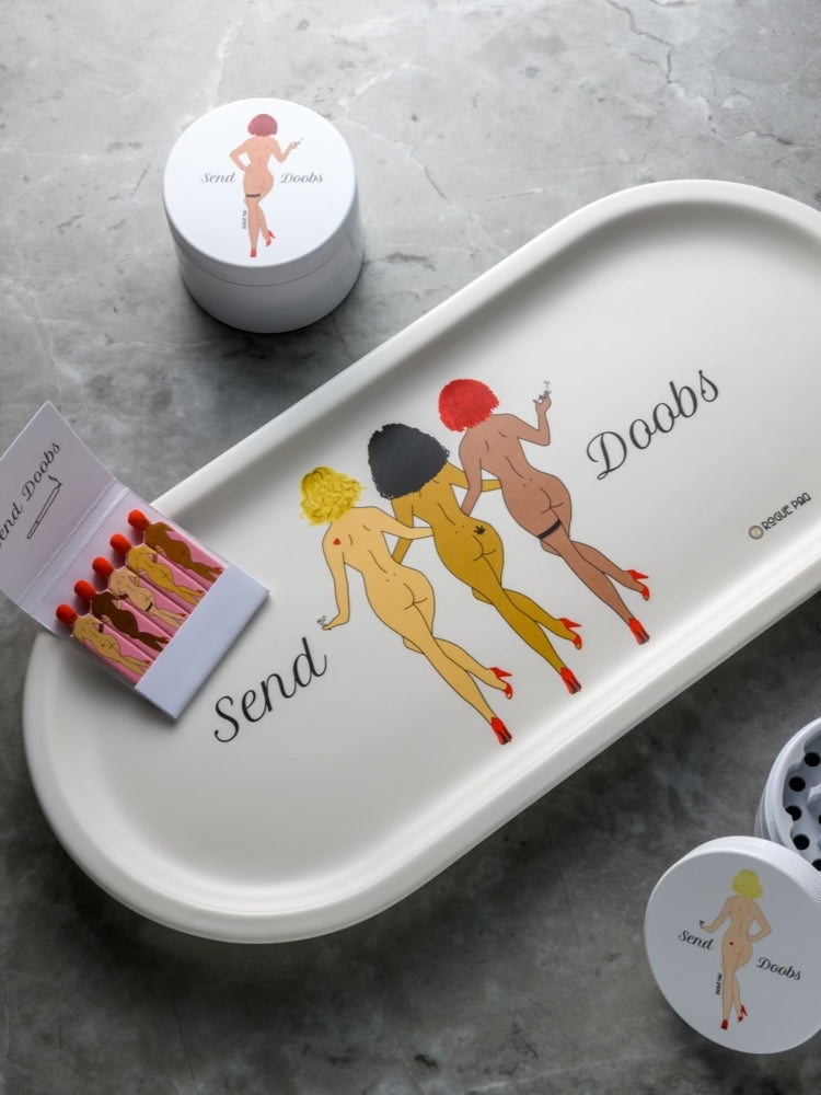 Rogue Paq SendNudes Send Doobs Gift Set featuring a porcelain valet tray, ceramic grinder, and vintage-style matches; a playful and coordinated collection for the ultimate cannabis ritual