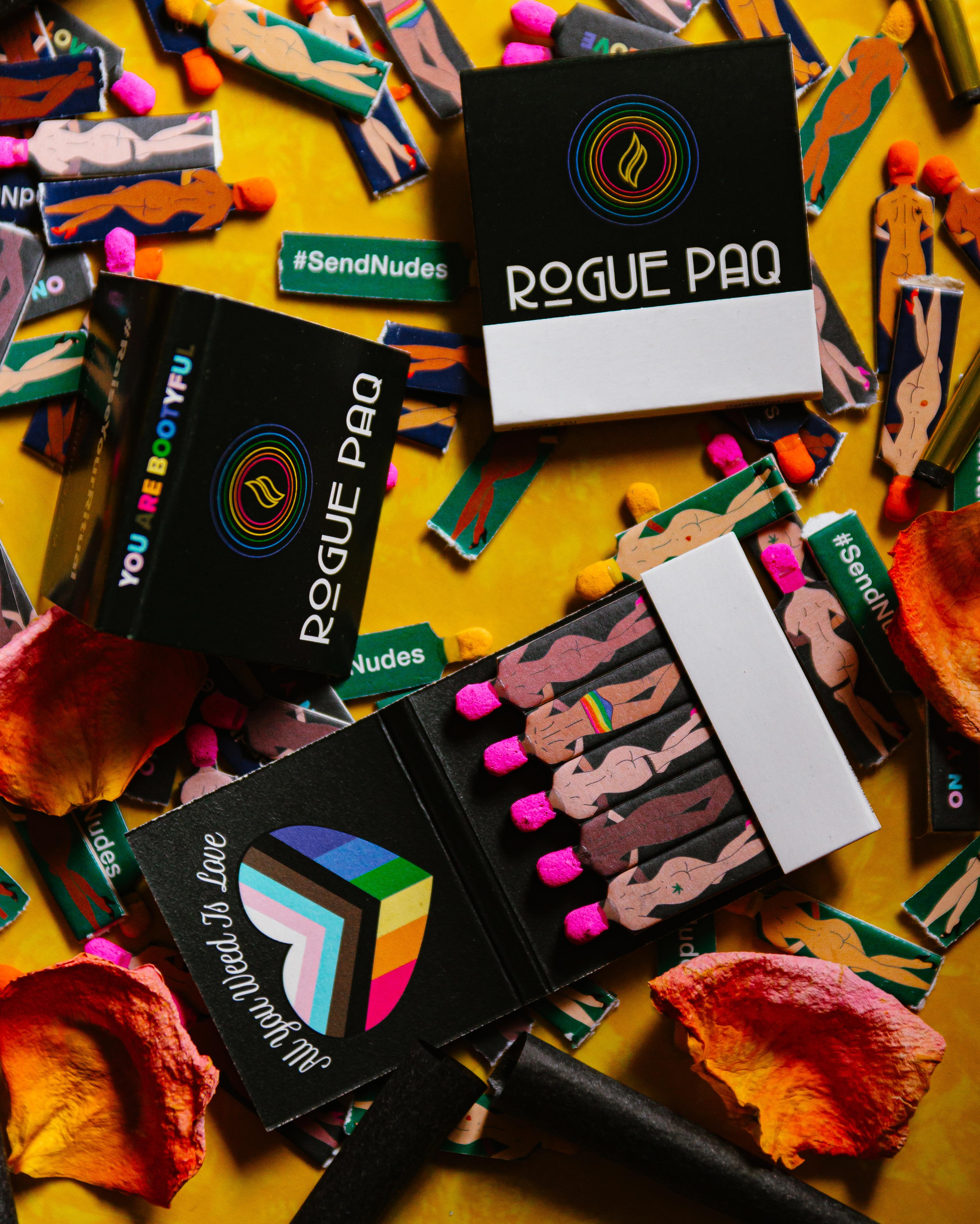 Scattered All You Weed Is Love vintage-style matchbooks featuring diverse figures with the rainbow flag inside a heart; perfect for celebrating Pride or gifting to a cannabis-loving partner.