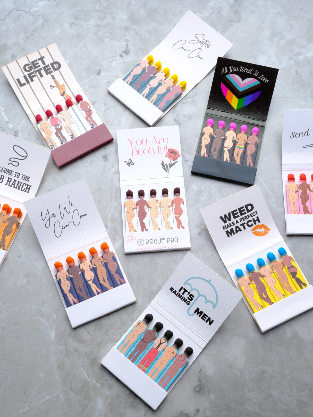 A curated bundle of all 9 styles of  Rogue Paq SendNudes matchbooks. The bundle includes three books of each of the 9 matchbook styles featured here. The books, feature diverse, artistic pin-up figures in high-kick dance poses. Each matchbook has its own uplifting saying inside.