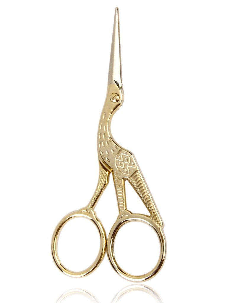A pair of gold-toned precision trim scissors designed in the shape of a crane. The body of the bird forms the handles, while the long, slender beak serves as the sharp, stainless steel blades, finished in a high-polish gold for a luxury aesthetic.