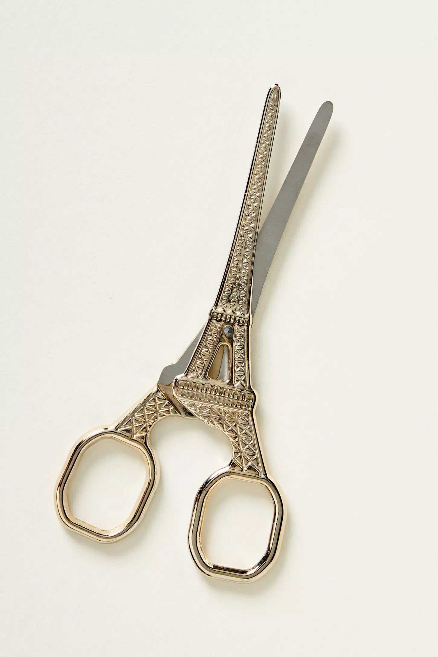Decorative scissors shaped like the Eiffel Tower, featuring gold-toned handles and silver-toned blades, set against a plain white background.
