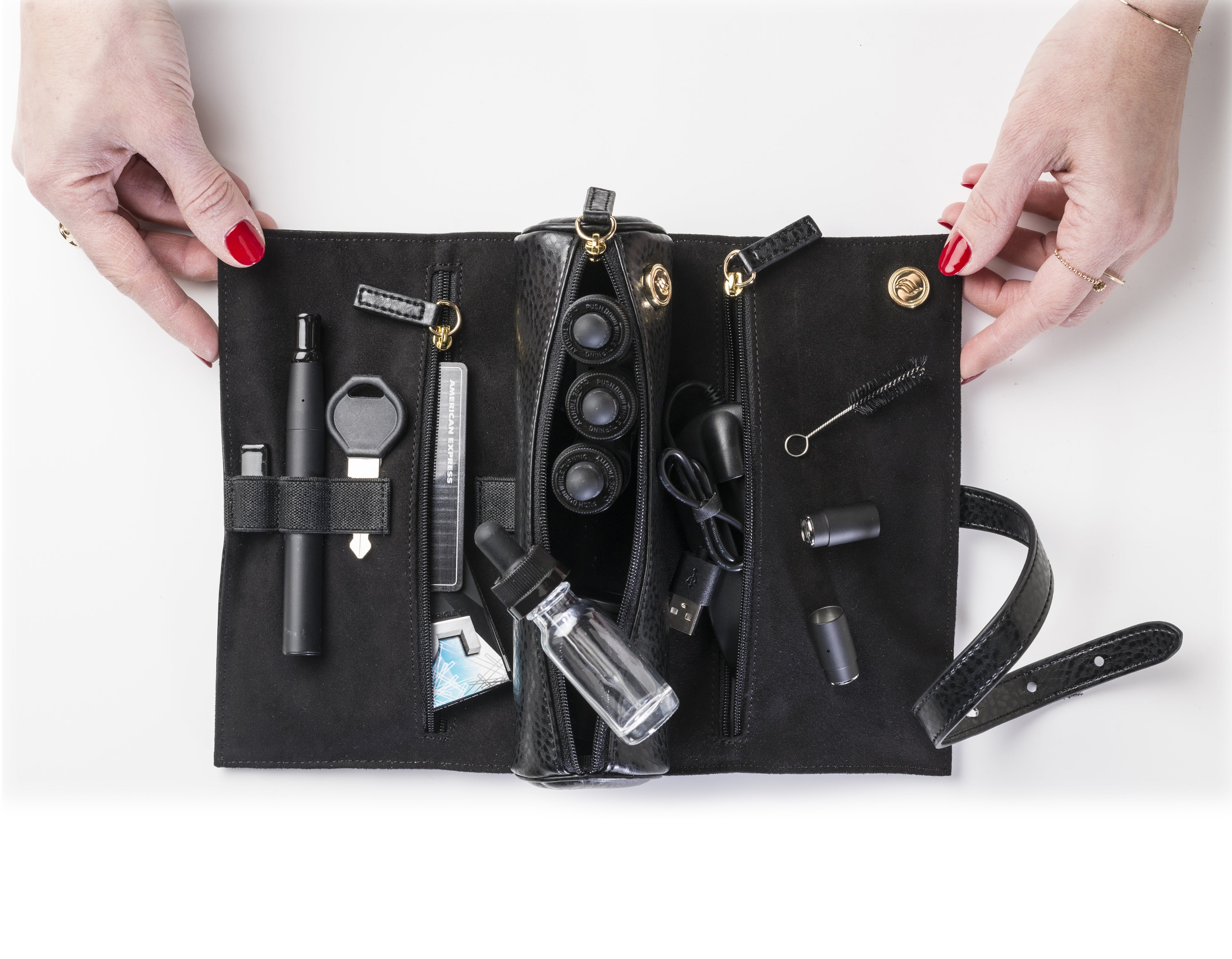 Woman's hands opening Rogue Paq Black vegan leather cannabis carrier 