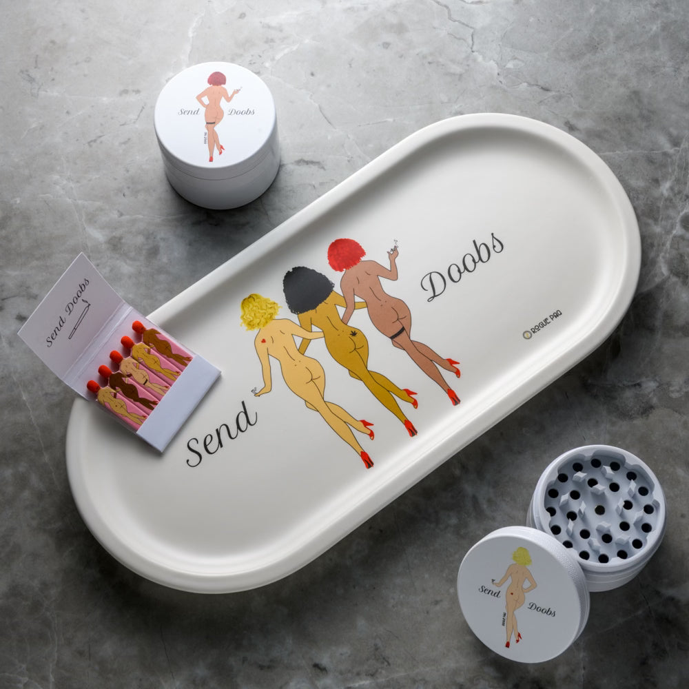 Rogue Paq SendNudes Send Doobs Gift Set featuring a porcelain valet tray, ceramic grinder, and vintage-style matches; a playful and coordinated collection for the ultimate cannabis ritual. These are some of our highest rated cute smoking accessories.
